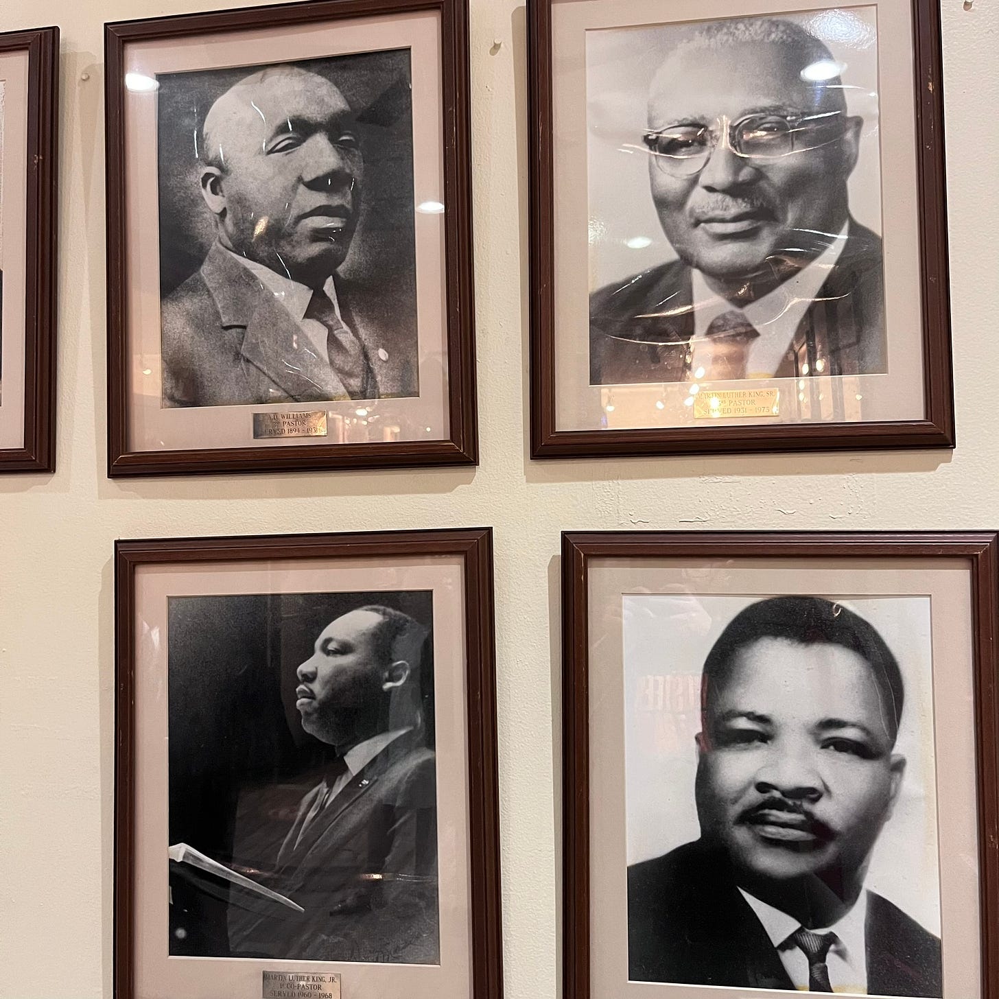 A photograph of four framed black and white portraits of four men: A.D. Williams, Martin Luther King Sr., Martin Luther King Jr., and A.D. King. All four men preached at Ebenezer Baptist Church.
