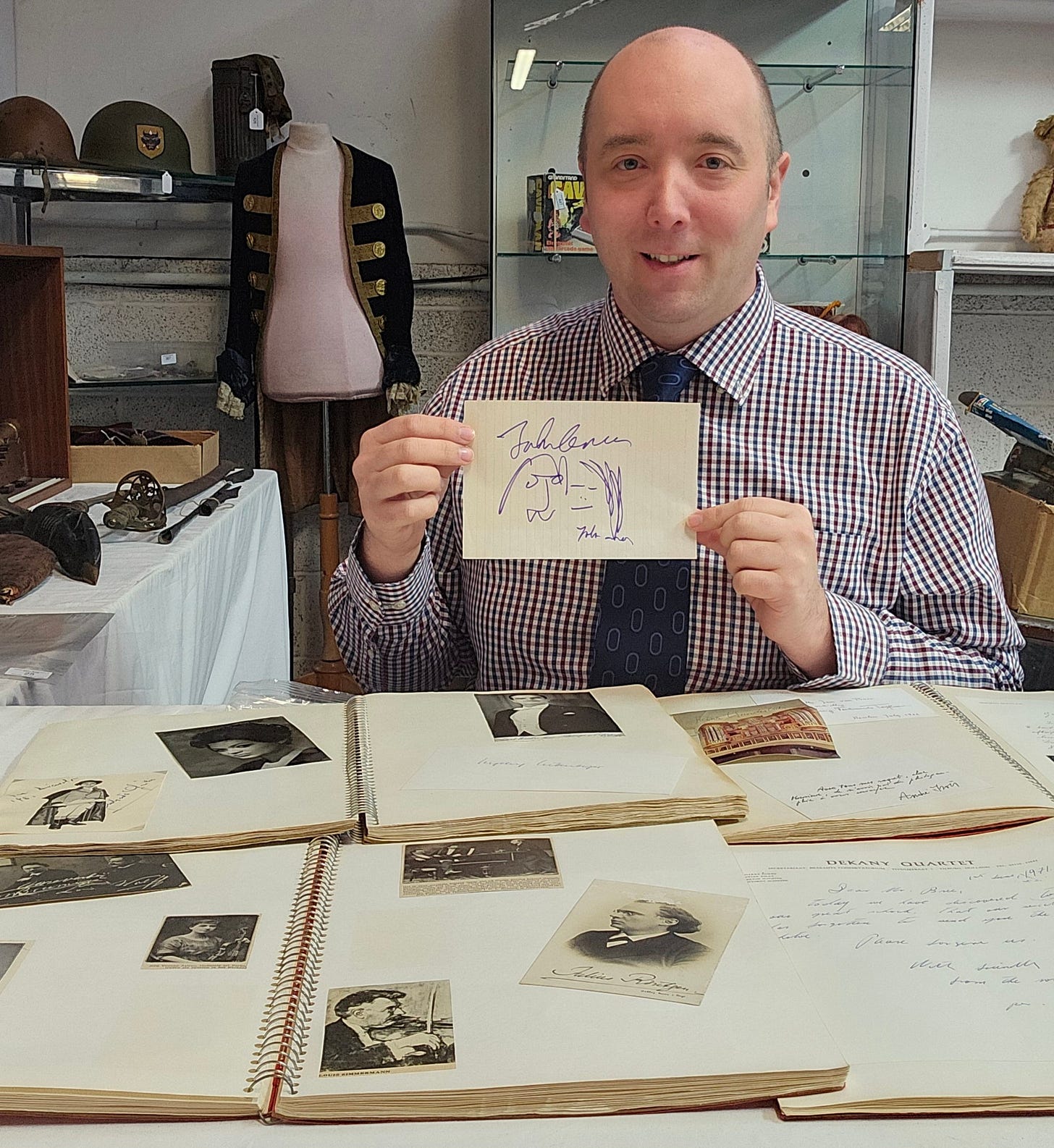 Auctioneer Andrew Stowe with a John Lennon autograph