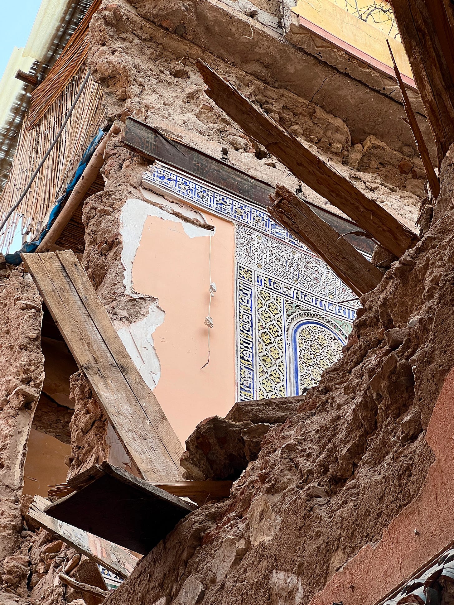 Partially collapsed building in Marrakech after the earthquake, exposing an interior wall with intricate Moroccan tilework and damaged wooden beams surrounded by rubble. Partially collapsed building in Marrakech after the earthquake, exposing an interior wall with intricate Moroccan tilework and damaged wooden beams surrounded by rubble.