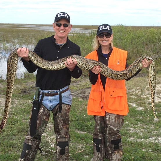 A couple holding a Burmese python