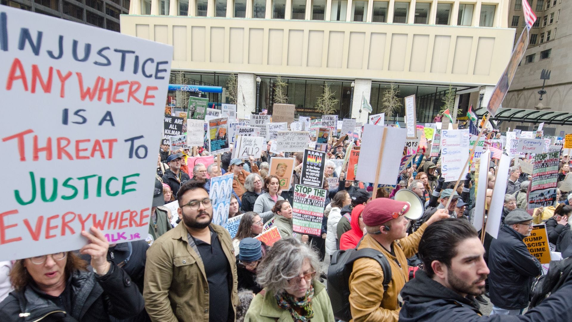 Photo of a group of protesters in a city plaza. Photo of a group of protesters in a city plaza.