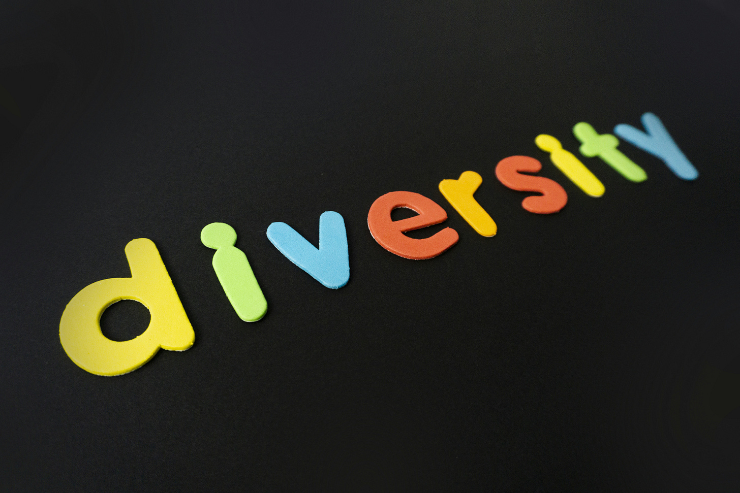 the word "diversity" each letter is a different color over a solid black background