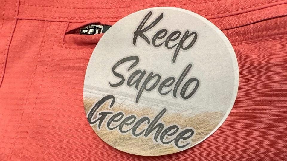 A sticker saying "Keep Sapelo Geechee" is worn on the shirt of George Grovner, a resident of the Hogg Hummock community on Sapelo Island, during a meeting of McIntosh County commissioners in Darien, Georgia, in September 2023. - Russ Bynum/AP