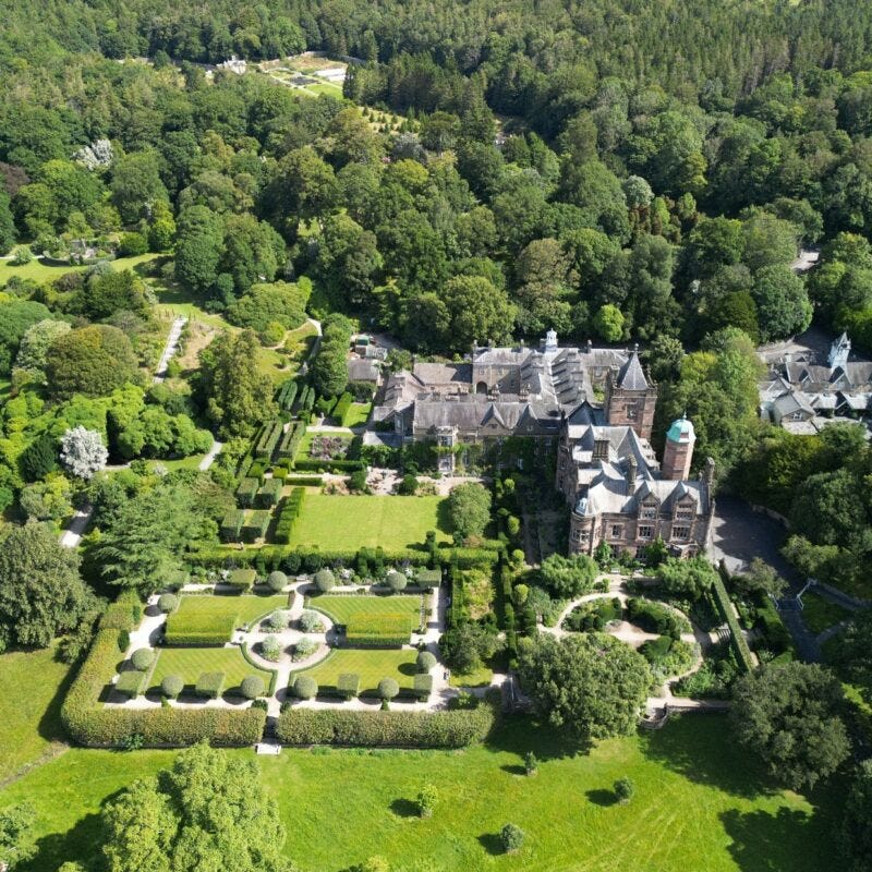 A large mansion surrounded by treesDescription automatically generated