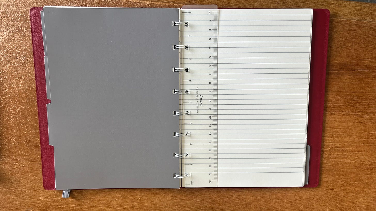 A red Filofax Refillable Notebook lays open on a desk. The rule and a divider are on display. Photo: Roland Millward A red Filofax Refillable Notebook lays open on a desk. The rule and a divider are on display. Photo: Roland Millward