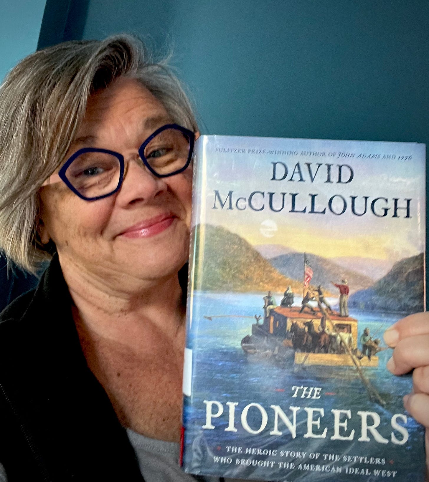 Tamela Rich holding the book "The Pioneers" by David McCullough