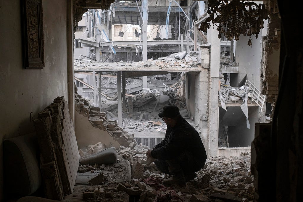 A man searches for his belongings among the ruins of his apartment near a police station in a residential area in Tehran, Iran, March 15, 2026.