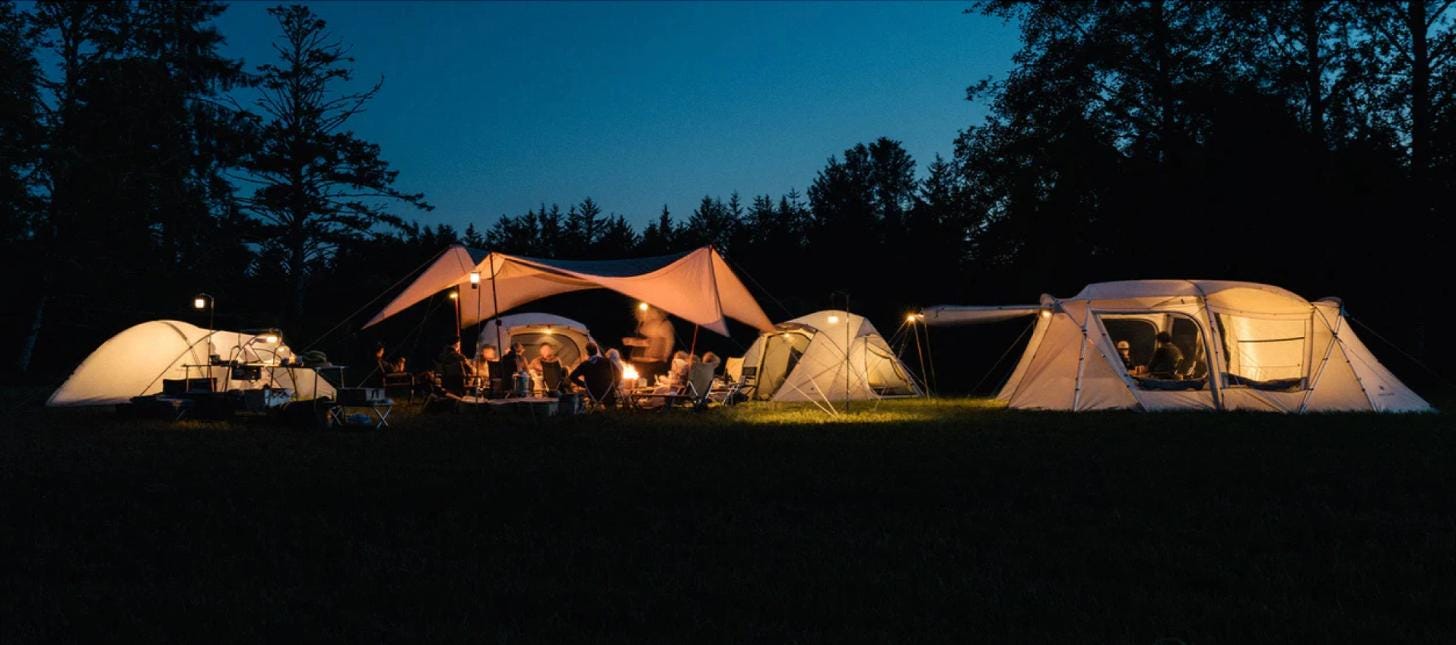 Camping tents illuminated at night in a forest setting Camping tents illuminated at night in a forest setting