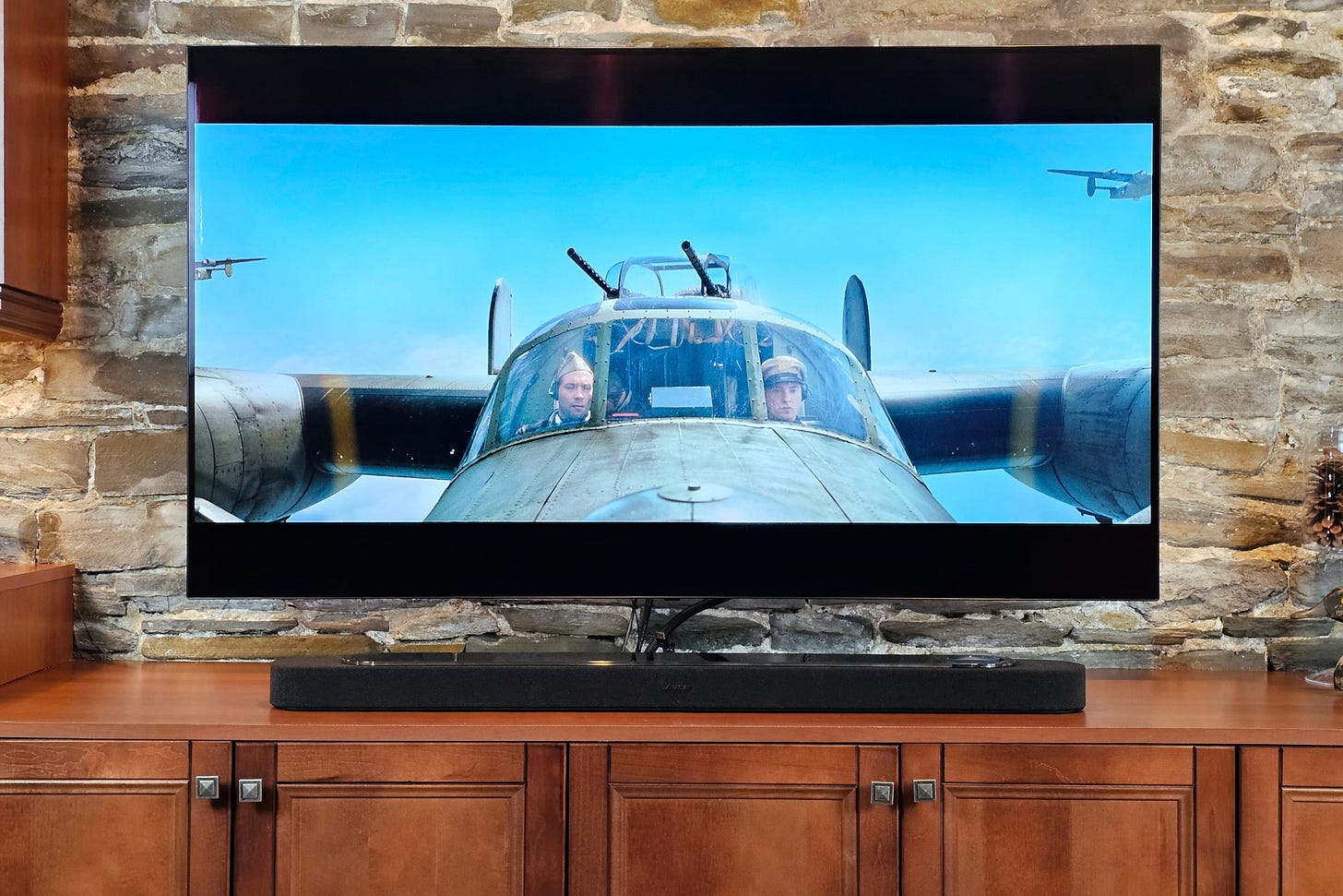 Bose Lifestyle Ultra Soundbar sitting in front of a TV playing the movie Unbroken.