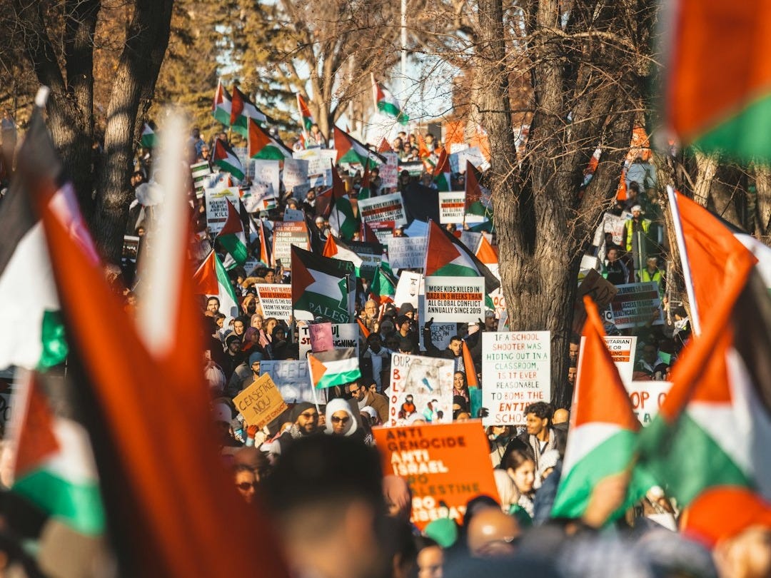 a crowd of people holding orange and green flags