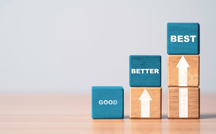 Good better and best wording on blue wooden cube block with white up arrow for product and service quality continuous improvement or Kaizen concept.