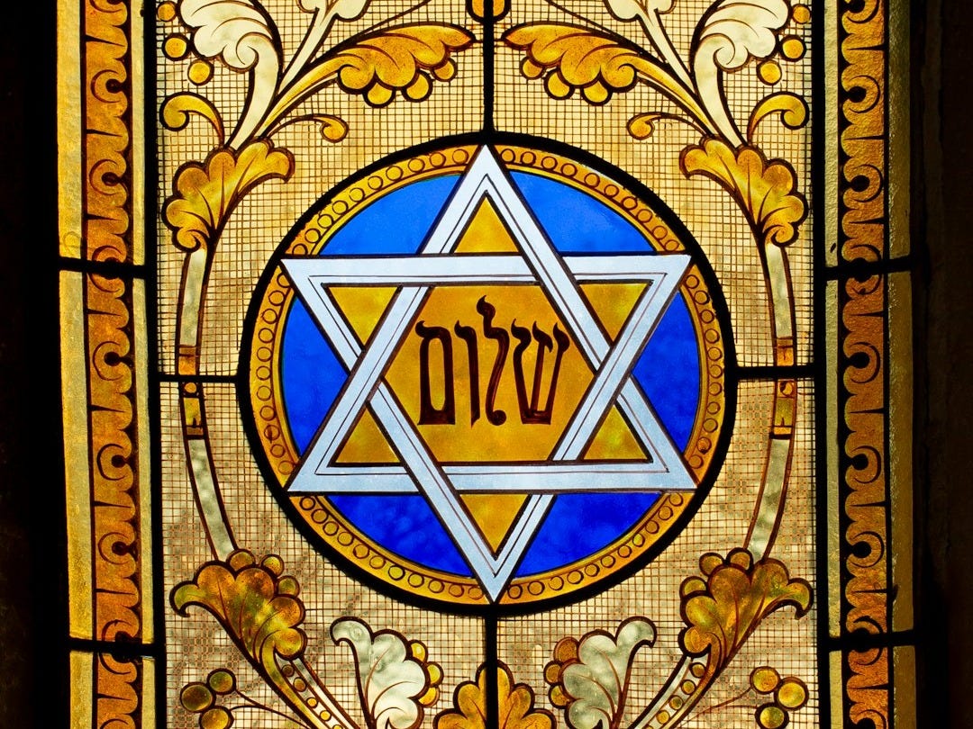 a stained glass window with a star of david on it a stained glass window with a star of david on it