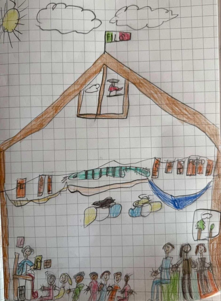 Un disegno infantile su carta a quadretti che rappresenta l'interno di una grande casa o capanna sotto un sole e delle nuvole. In basso a sinistra, una figura seduta legge un libro a un gruppo di bambini seduti a terra. A destra, tre figure adulte stanno in piedi o sedute. Al centro del disegno ci sono vari elementi colorati, tra cui quello che sembra un grosso pesce verde a strisce, delle amache e piccoli quadri appesi. Sul tetto sventola una bandiera tricolore con la scritta "FILÒ"
