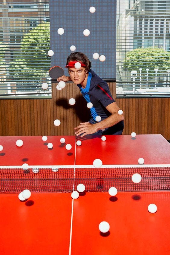 This may contain: a man is playing ping pong in an office setting with lots of white balls