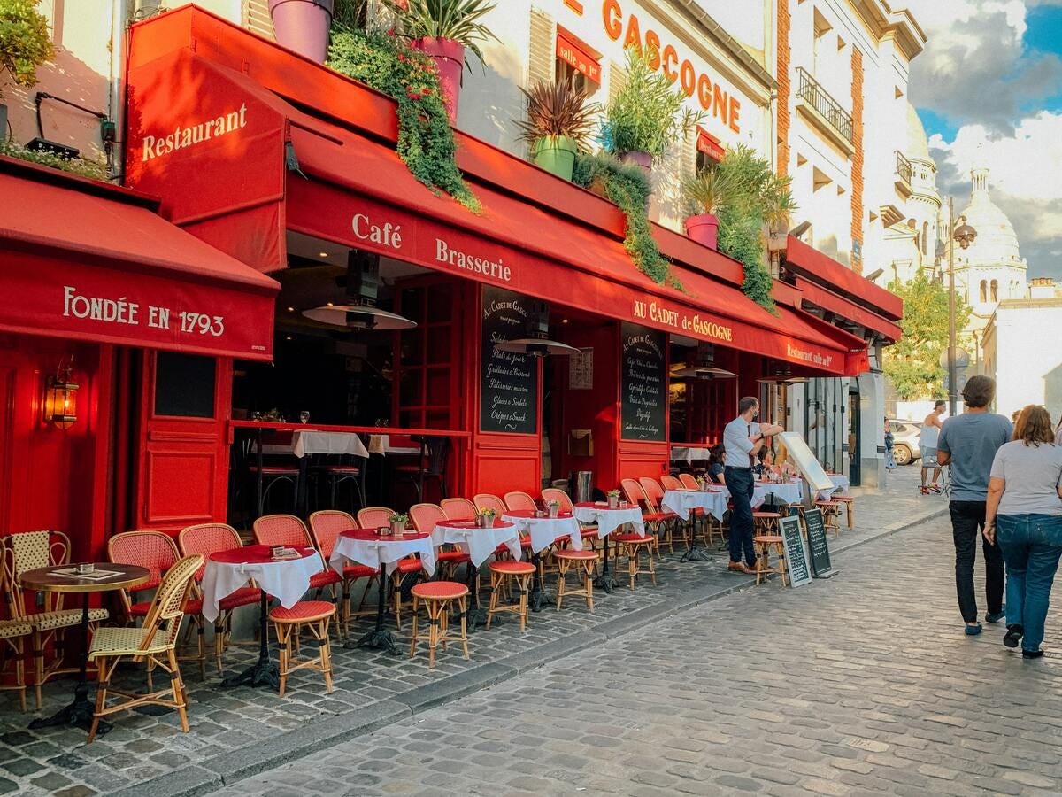 The street outside an all-red Parisian bistro on a sunny day