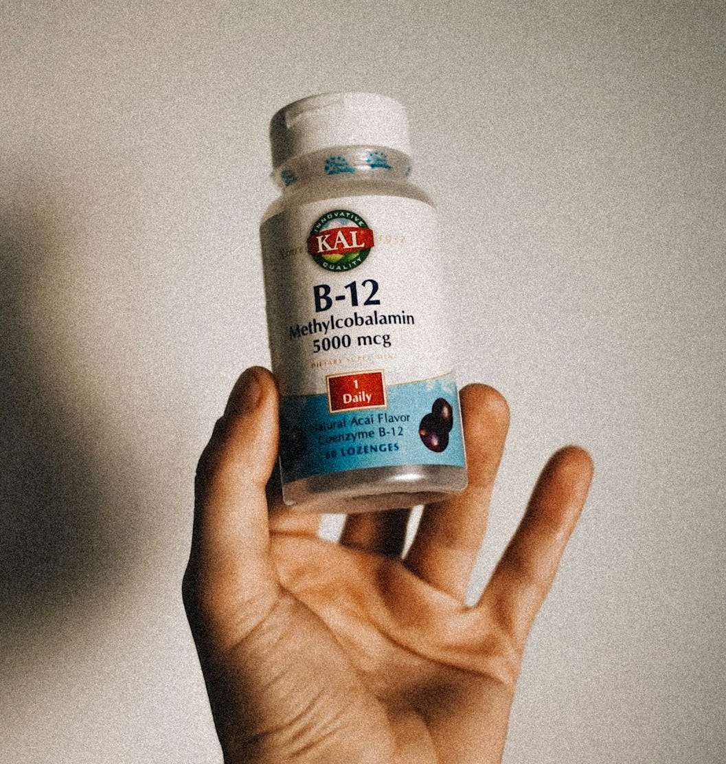 a person holding a bottle of vitamins in their hand