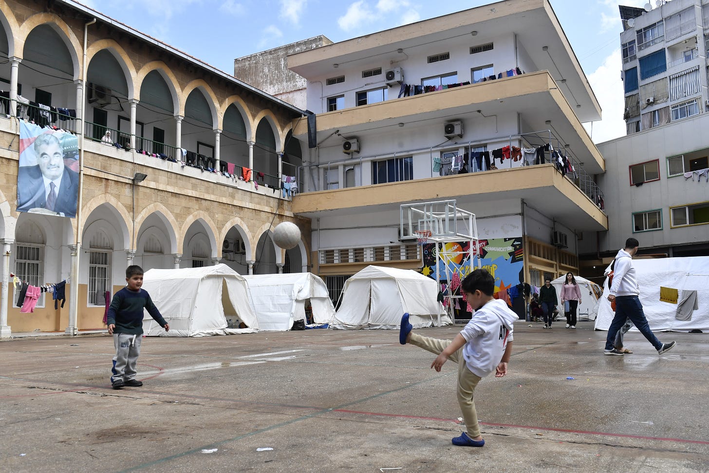 Lebanese families live in classrooms and tents set up in a school’s schoolyard after being forced to flee their homes in southern Beirut.