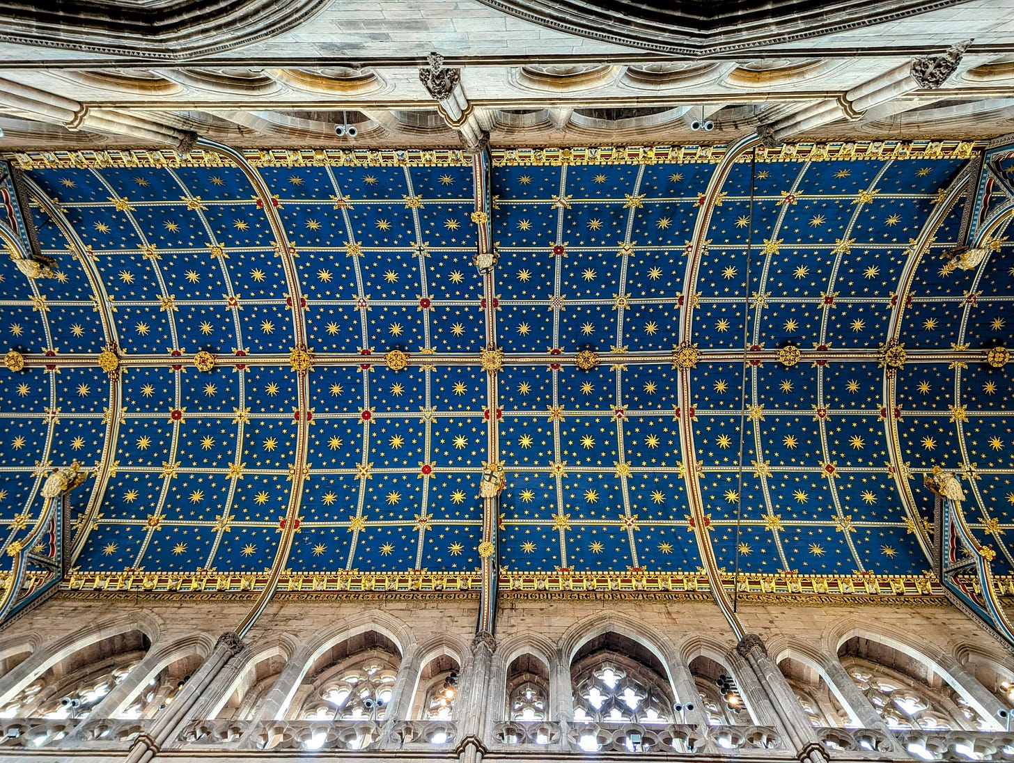 The Medieval barrel-vaulted ceiling and its Victorian decoration by renowned architect Owen Jones. The geometric blue and gold ceiling features stars, suns, angels, heraldic symbols and a roof boss depicting St Mary.