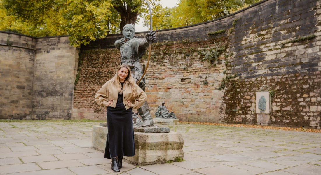 A woman - Eve Smallman - standing in front of the Robin Hood statue with her hands on her hips A woman - Eve Smallman - standing in front of the Robin Hood statue with her hands on her hips