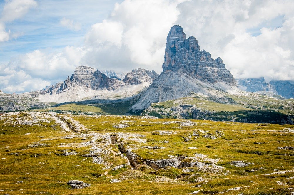 rock formation on wide field grass under cloudy blue sky during daytime rock formation on wide field grass under cloudy blue sky during daytime