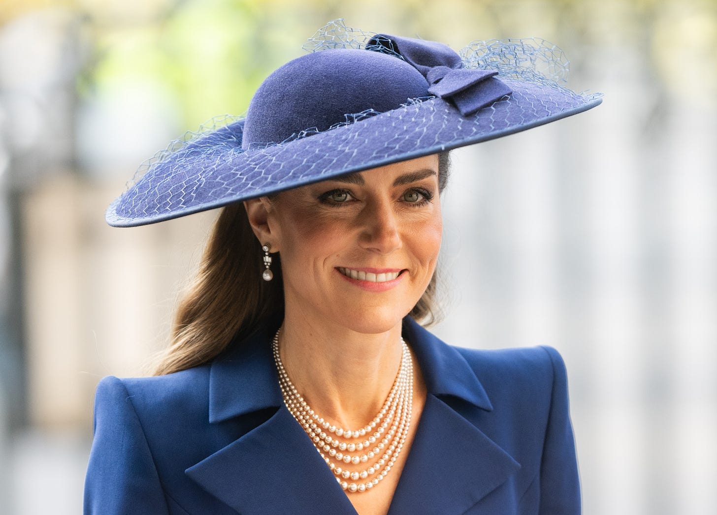 Princess Catherine smiling wearing a blue dress and blue hat