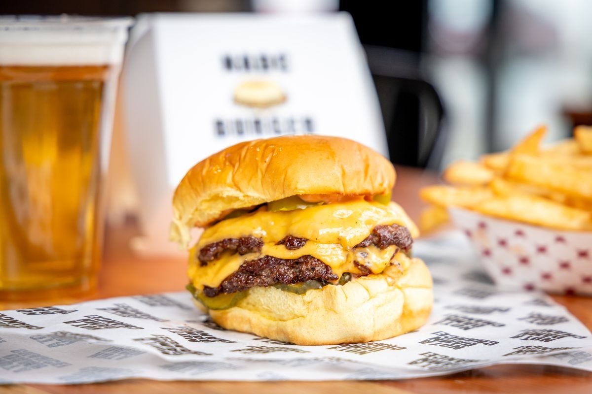 A double-meat patty cheeseburger on a table.