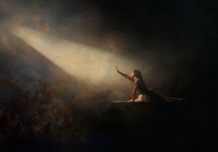 This may contain: a woman sitting on top of a surfboard under a bright light in the dark