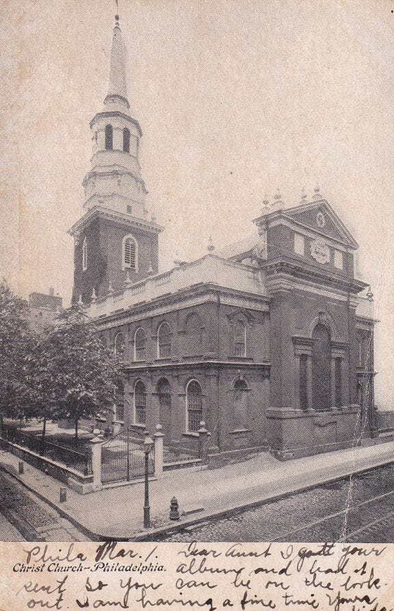 An antique postcard of Christ Church in Phaldelphia, a black and white image from the early 20th century. The church is made of red brick and has a tall, iconic white steeple. The ground are small and surrounded by a fence. An antique postcard of Christ Church in Phaldelphia, a black and white image from the early 20th century. The church is made of red brick and has a tall, iconic white steeple. The ground are small and surrounded by a fence.