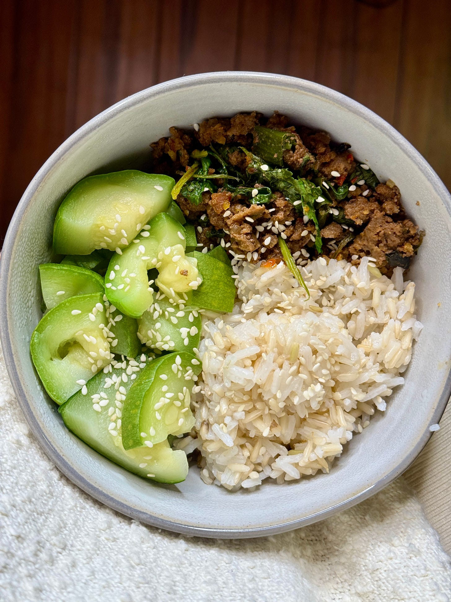 Thai basil beef bowls with ground beef, zucchini, brown rice, fresh cilantro, and green onions, topped with fragrant Thai basil.