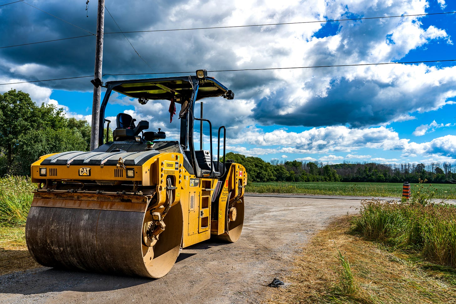 Photo of a steamroller near some countryside to be developed