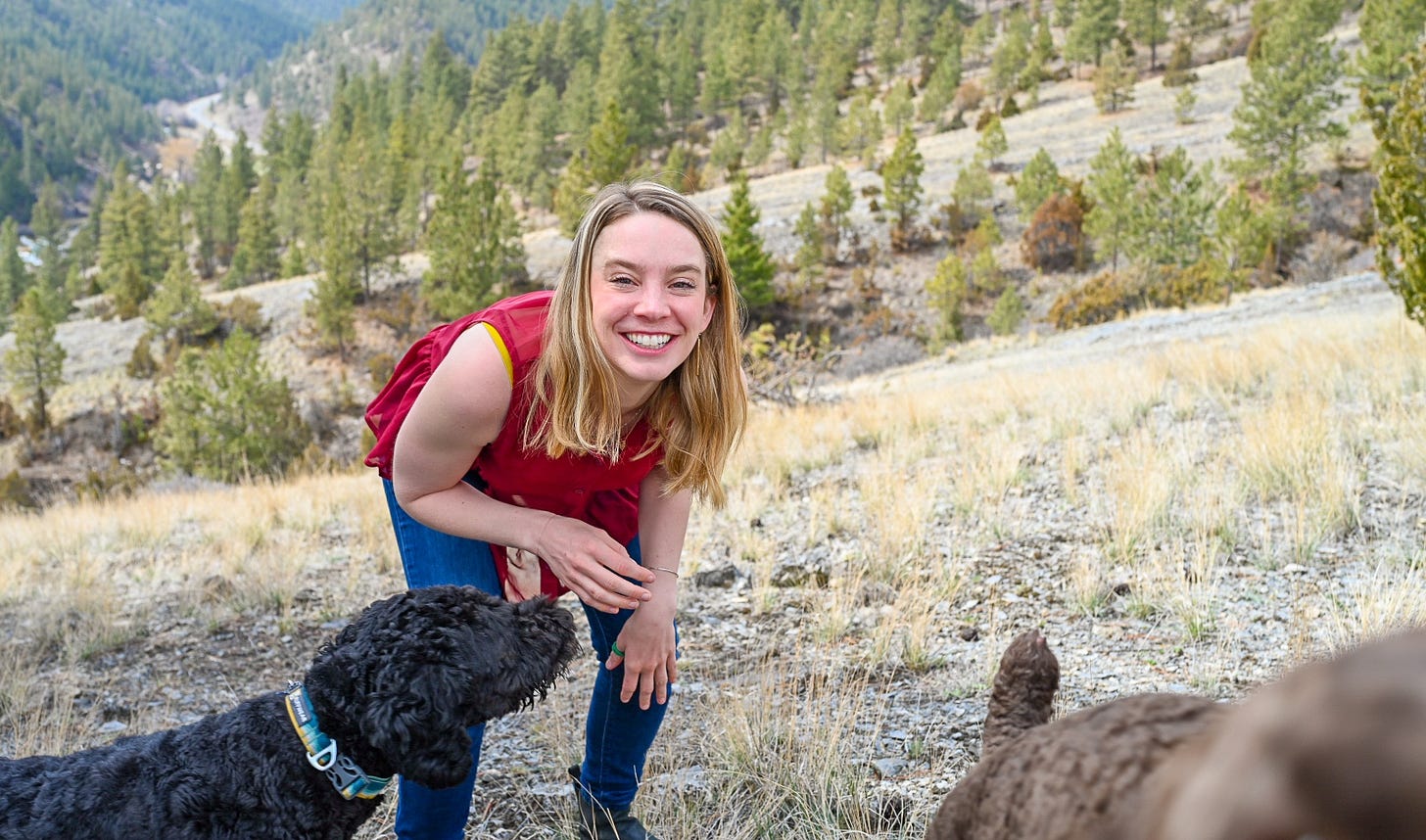 woman in red shirt in forest with dogs