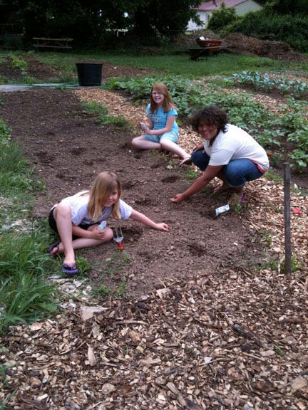 Diverse families--African American, Burmese. Latina, and white--in a Charlottesville, VA, community garden.