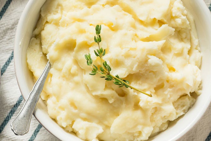 Drain the potatoes and garlic and mash together. Stir in the hot milk, season to taste with salt and pepper, and add the 2 tablespoons butter (less if desired) or oil. Top with remaining 1 tablespoon butter pat, serve immediately. Drain the potatoes and garlic and mash together. Stir in the hot milk, season to taste with salt and pepper, and add the 2 tablespoons butter (less if desired) or oil. Top with remaining 1 tablespoon butter pat, serve immediately.