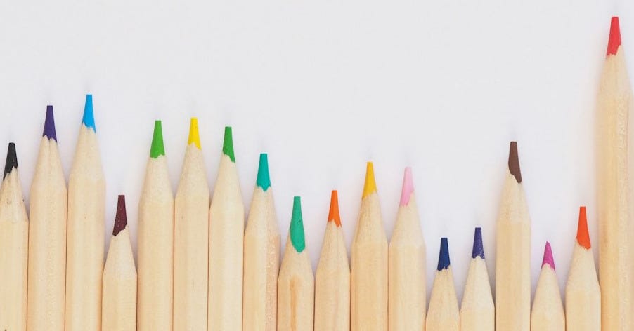 colored pencil lined up on top of white surface colored pencil lined up on top of white surface