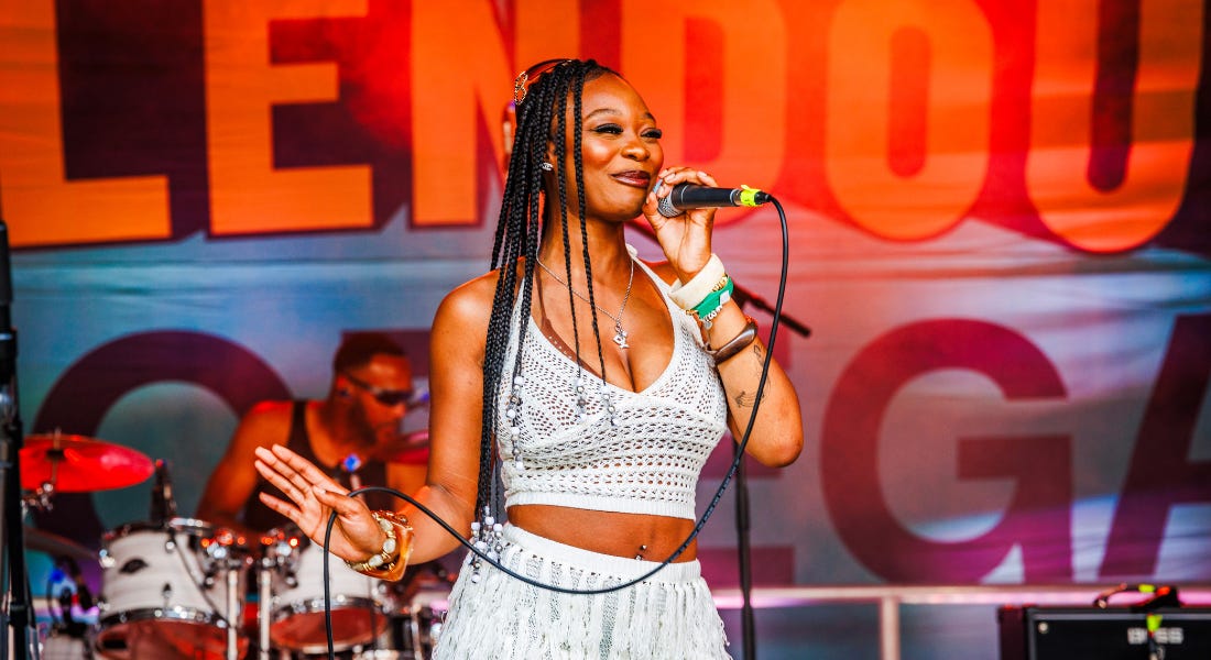 A woman wearing a white two-piece outfit holding a microphone with a wire A woman wearing a white two-piece outfit holding a microphone with a wire