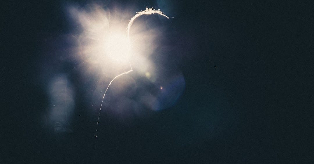 a person standing in the dark with a bright light behind them