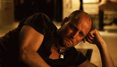 a bald man is laying on the floor with his hand on his chin . a bald man is laying on the floor with his hand on his chin .