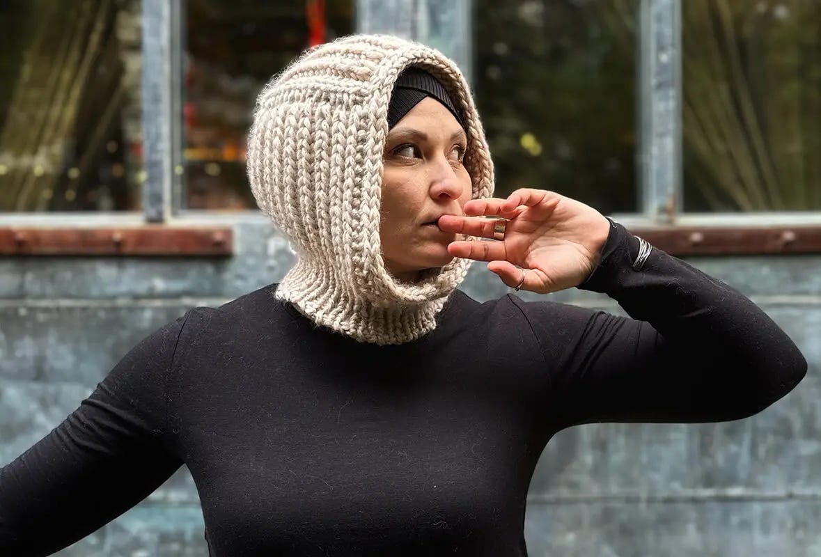 woman wearing black long sleeve t-shirt and beige knitted balaclava