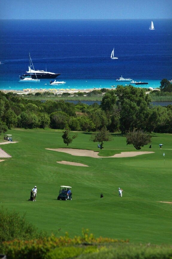 This may contain: people are playing golf on the green by the ocean