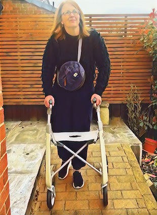 Jane walks with her byACRE oyster white collator, she's wearing a thick navy shaggy jumper, joggers and black and white trainers