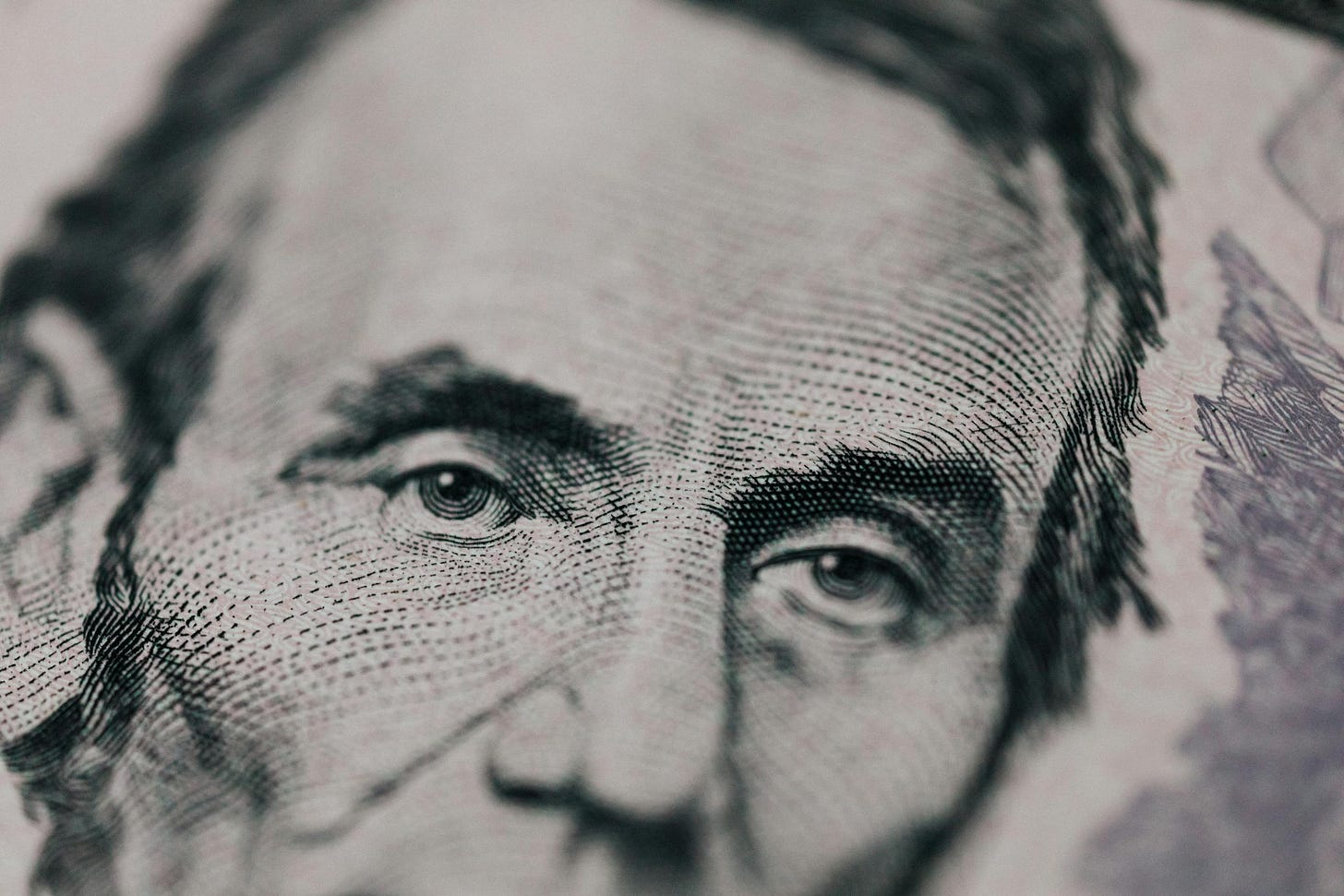 Closeup of male American president printed on five dollar bill and looking away pensively - rising cost of living 2025