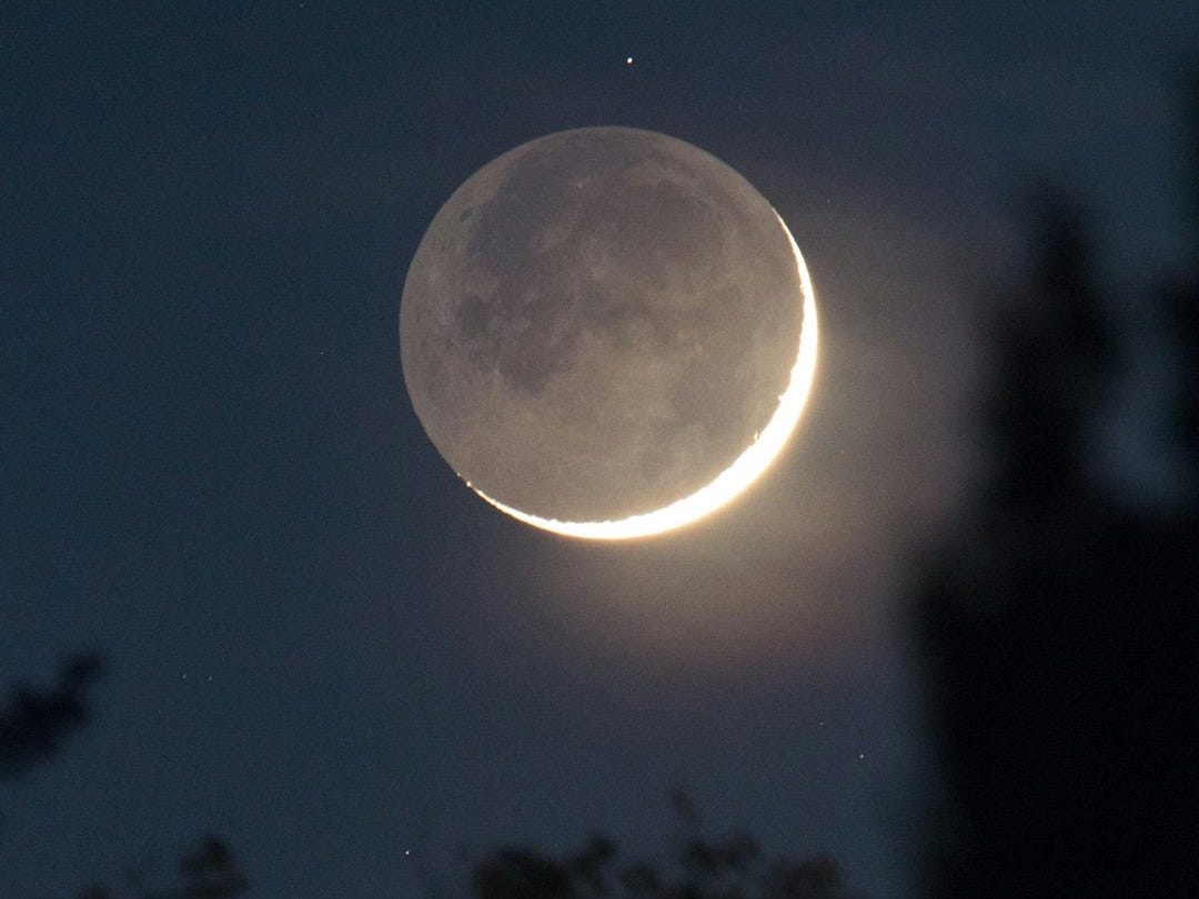 a crescent moon is seen in the night sky