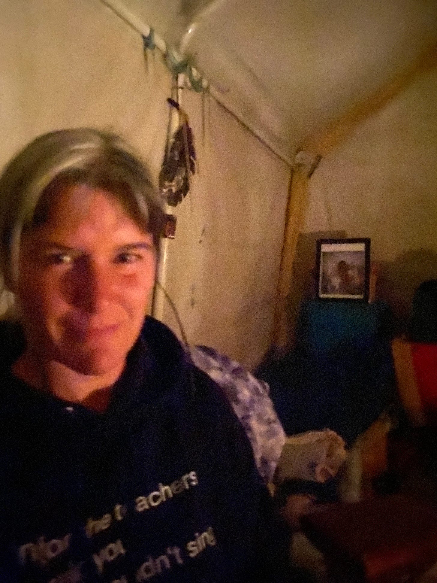 A selfie of me in my tent, face glowing from candlelight, wearing an oversize hoodie displaying the quote in the caption A selfie of me in my tent, face glowing from candlelight, wearing an oversize hoodie displaying the quote in the caption