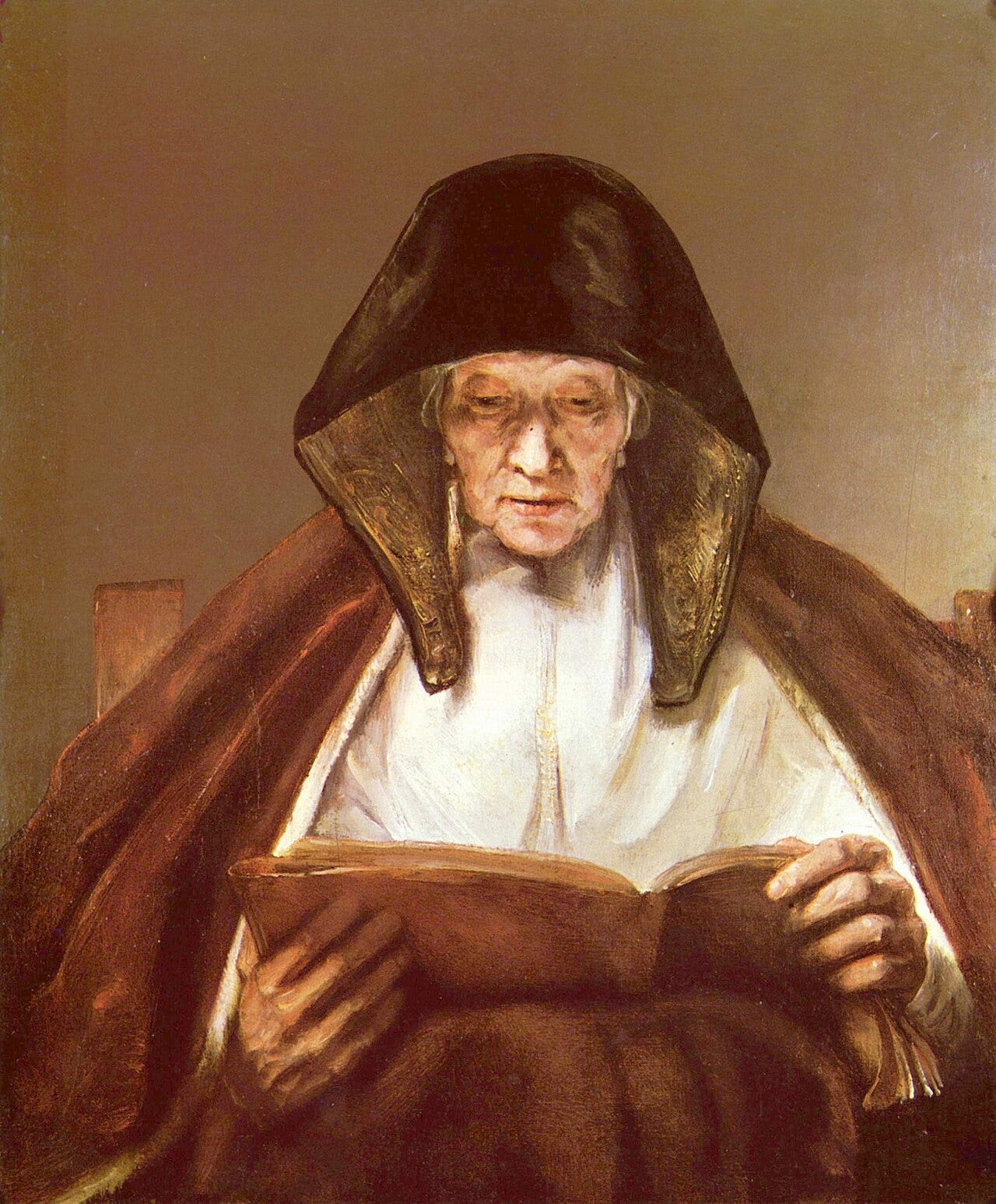 An old woman bends over a large book, her lined face lit softly from the page An old woman bends over a large book, her lined face lit softly from the page