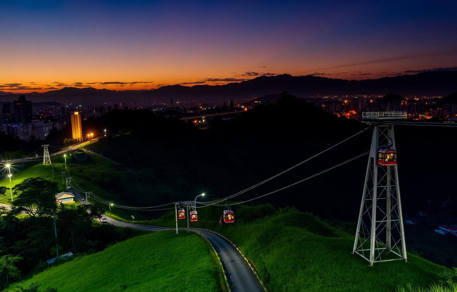 Medellín hillside skyline at dusk with cable cars and city lights