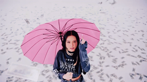 a close up of a woman holding an umbrella with a pink background