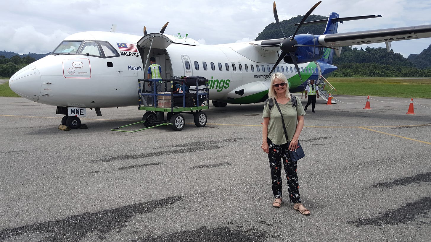 Jo Castro stands in front of a small plane.