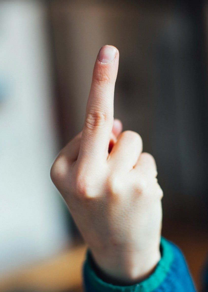 person in blue long sleeve shirt showing right middle finger