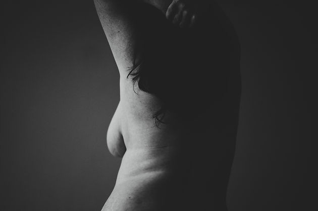  Image of the back of a woman with a portion of her breast in view.