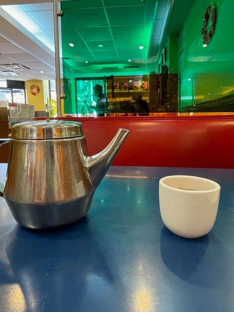 silver tea kettle and small tea cup on blue table at Wo Hop Next Door
